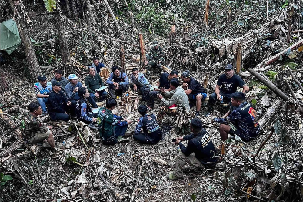 This handout image released by Metta Tham Rescue Kalasin on May 26, 2026, shows rescue workers gathering near a cave in Xaisomboun province. (Photo by Handout / Metta Tham Rescue Kalasin / AFP) 