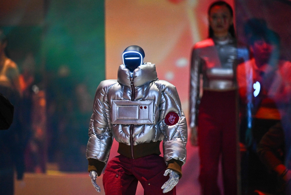 A humanoid robot and a model present creations at Galaxy Corporation's 