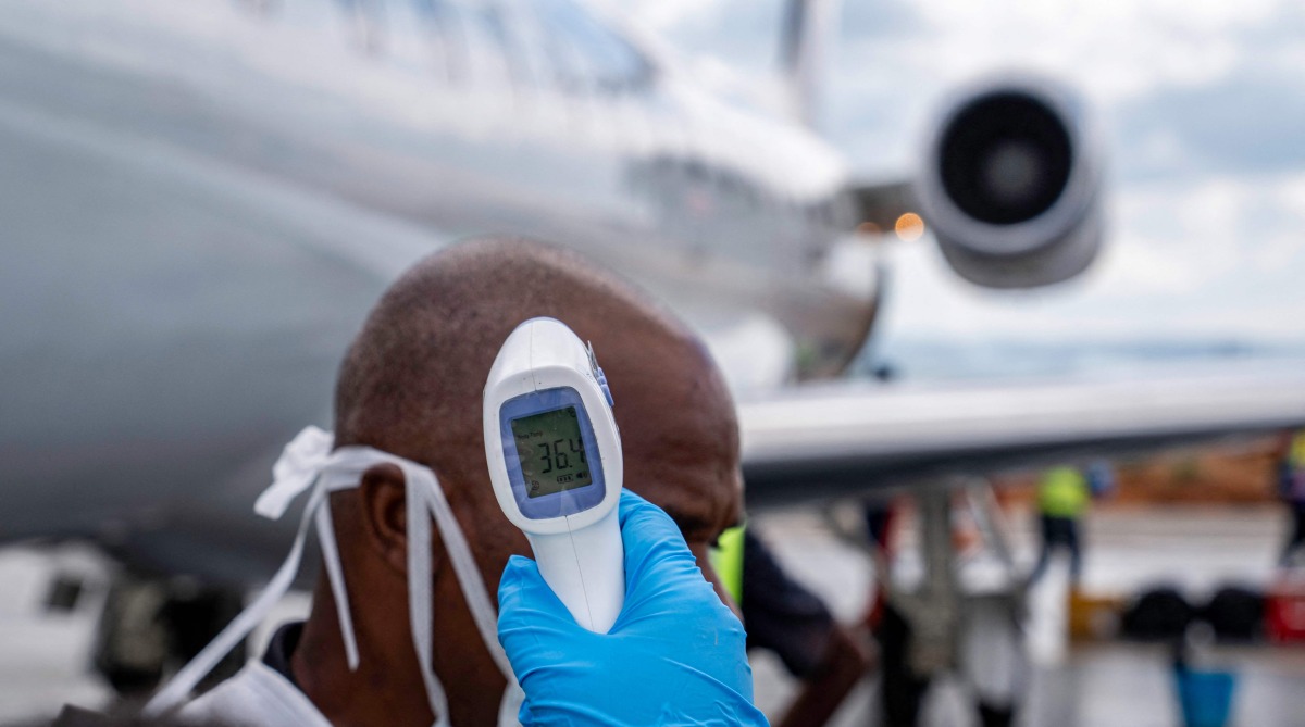 A passenger's temperature is checked at Bunia Airport in eastern Democratic Republic of the Congo on June 3, 2026. Photo by GLODY MURHABAZI / AFP