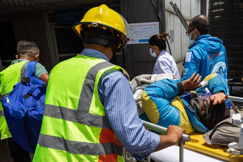 Medics and rescuers carry Mountaineer Dawa Sherpa upon his arrival at the HAMS Hospital in Kathmandu on June 4, 2026. (Photo by Prabin Ranabhat / AFP)