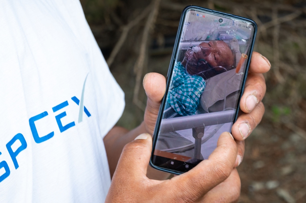Karma Gyaljen, a relative of mountaineer Dawa Sherpa, shows a photograph of Dawa Sherpa undergoing treatment in the intensive care unit (ICU) at HAMS Hospital in Kathmandu on June 5, 2026. (Photo by Prabin Ranabhat / AFP)