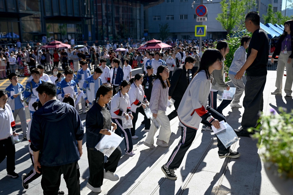 Students enter a school on the first day of China's National College Entrance Examination (NCEE) known as 