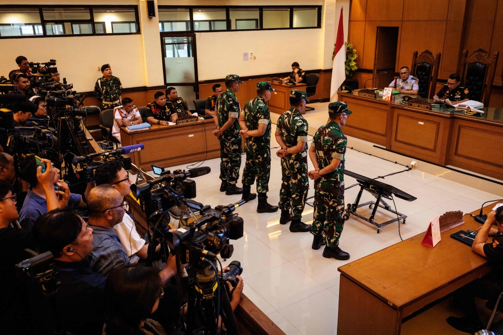 Four Indonesian military personnel accused of throwing acid at a human rights activist attend a verdict hearing at a military court in Jakarta on June 10, 2026. (Photo by Yasuyoshi Chiba / AFP)