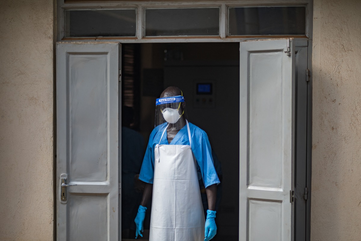 A health worker wearing a face mask as part of his personal protection equipment (PPE) looks on at the Mulago National Referral Hospital isolation unit in Kampala, Uganda, on July 8, 2026. Photo by BADRU KATUMBA / AFP