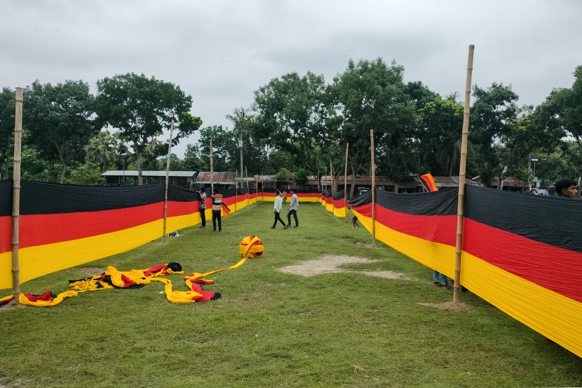 People look at a 7.5 kilometres (4.7 miles) long national flag of Germany commisioned by their football team fan Bangladeshi farmer Amjad Hossain, upon its display across a field in Magura district on June 10, 2026, on the eve of the 2026 FIFA World Cup tournament. Photo by AFP