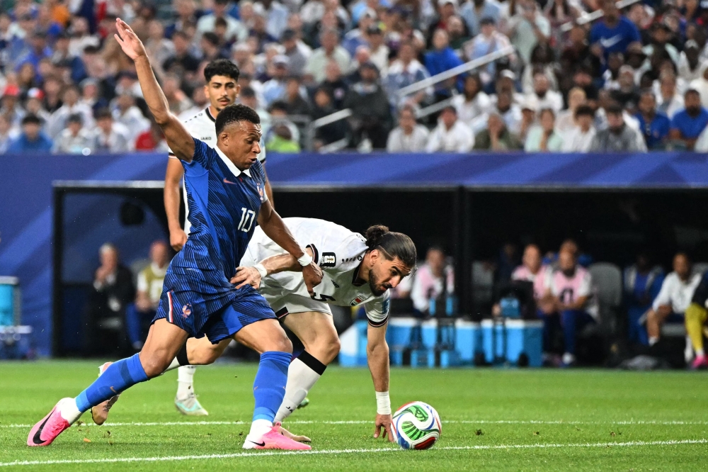 France's forward #10 Kylian Mbappe and Iraq's defender #05 Hashim Akam Rahman fight for the ball. (Photo by Roberto Schmidt / AFP)