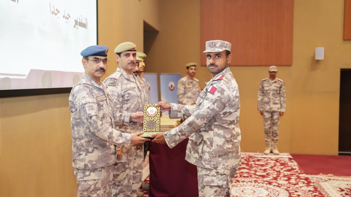 Senior military officials present an award to a graduate.
