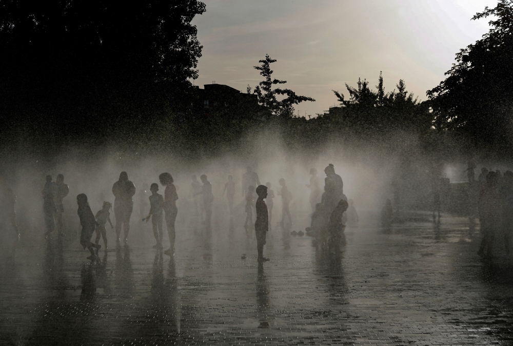 People off in a water fountain as Spain experiences a heatwave, in Madrid. (Photo by Oscar Del Pozo / AFP)