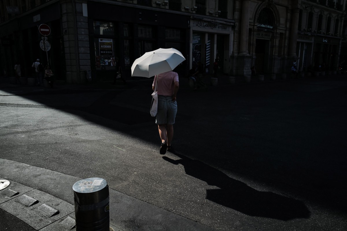 A woman walks under an umbrella to protect herself from the sun during a heatwave in Lyon, southern France, on June 24, 2026. Photo by OLIVIER CHASSIGNOLE / AFP