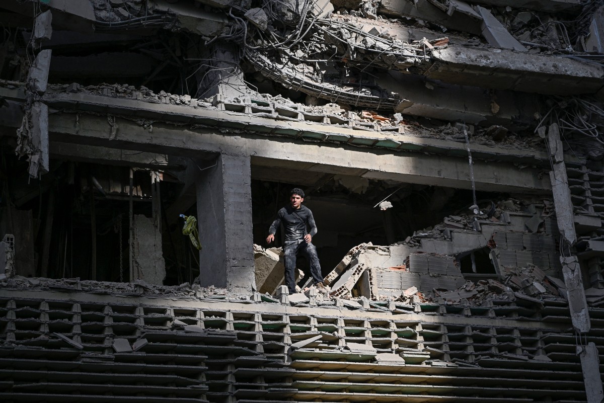 A man looks out from a damaged apartment building following an earthquake in Catia La Mar, La Guaira state, some 30km north-west of Caracas, on June 25, 2026. Photo by FEDERICO PARRA / AFP