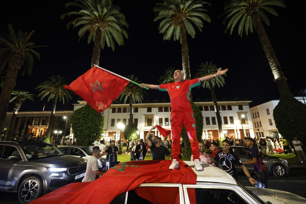 A man waves the Moroccan national flag as football fans celebrate Morocco's victory over the Netherlands in the Round of 32 of the 2026 World Cup, in Rabat early on June 30, 2026. (Photo by Abdel Majid Bziouat / AFP)
 