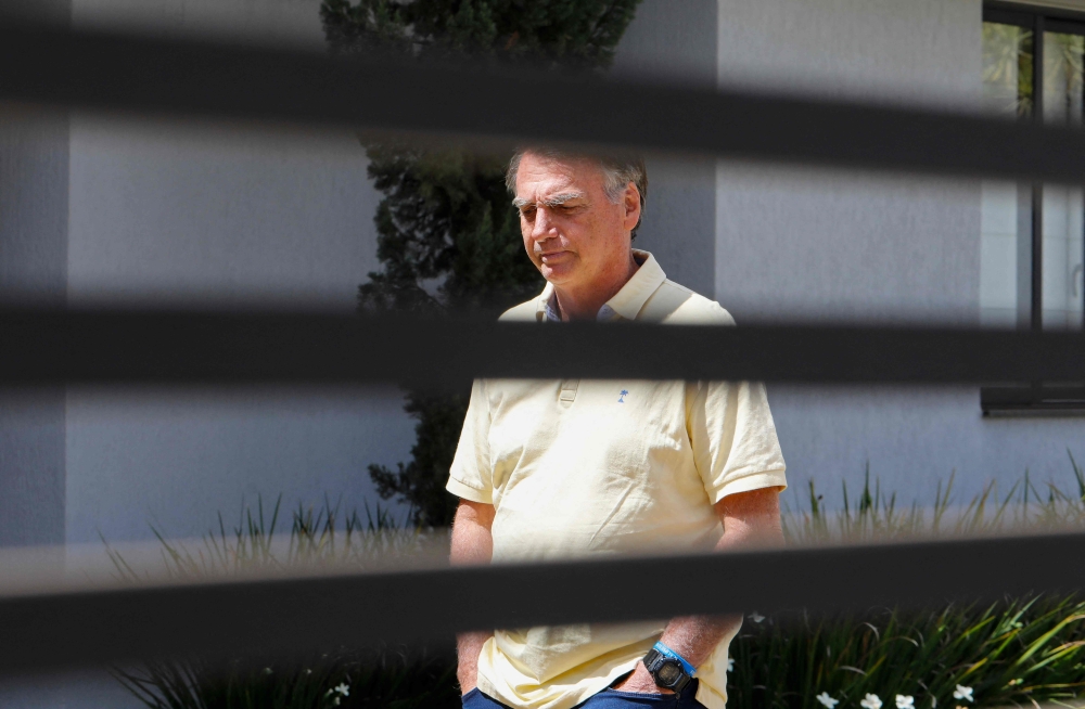 (FILES) Former Brazilian President Jair Bolsonaro gestures from his residence in Brasilia on September 3, 2025. (Photo by Sergio Lima / AFP)