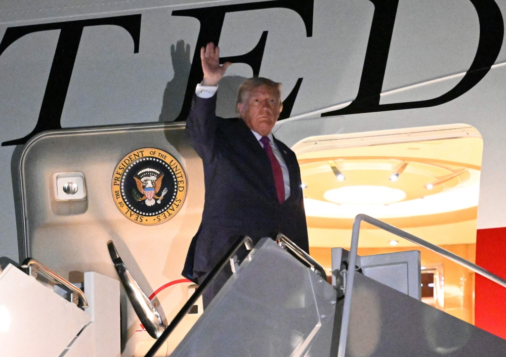 US President Donald Trump waves as he boards Air Force One at Ellsworth Air Force Base, South Dakota (Photo by Mandel Ngan/ AFP)