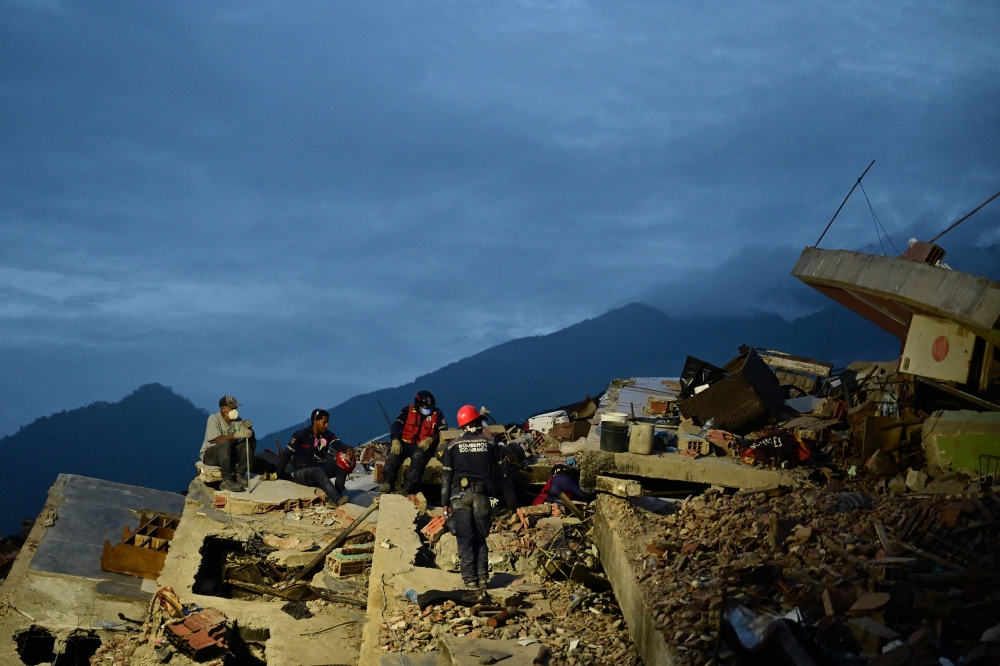Rescuers work on the rubble of a collapsed building in Caraballeda, La Guaira state, Venezuela, on July 3, 2026.  (Photo by MARTIN BERNETTI / AFP)
 