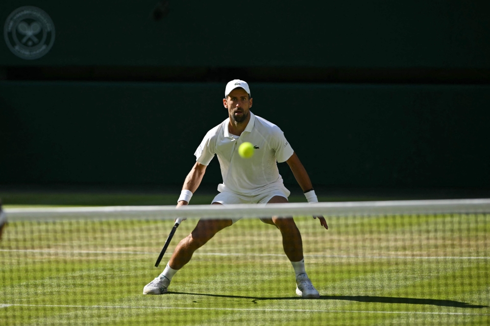 Serbia's Novak Djokovic prepares to return to France's Arthur Rinderknech during their men's singles third round tennis match on the fifth day of the 2026 Wimbledon Championships at The All England Lawn Tennis and Croquet Club in Wimbledon, southwest London, on July 3, 2026. (Photo by Glyn KIRK / AFP) 
 