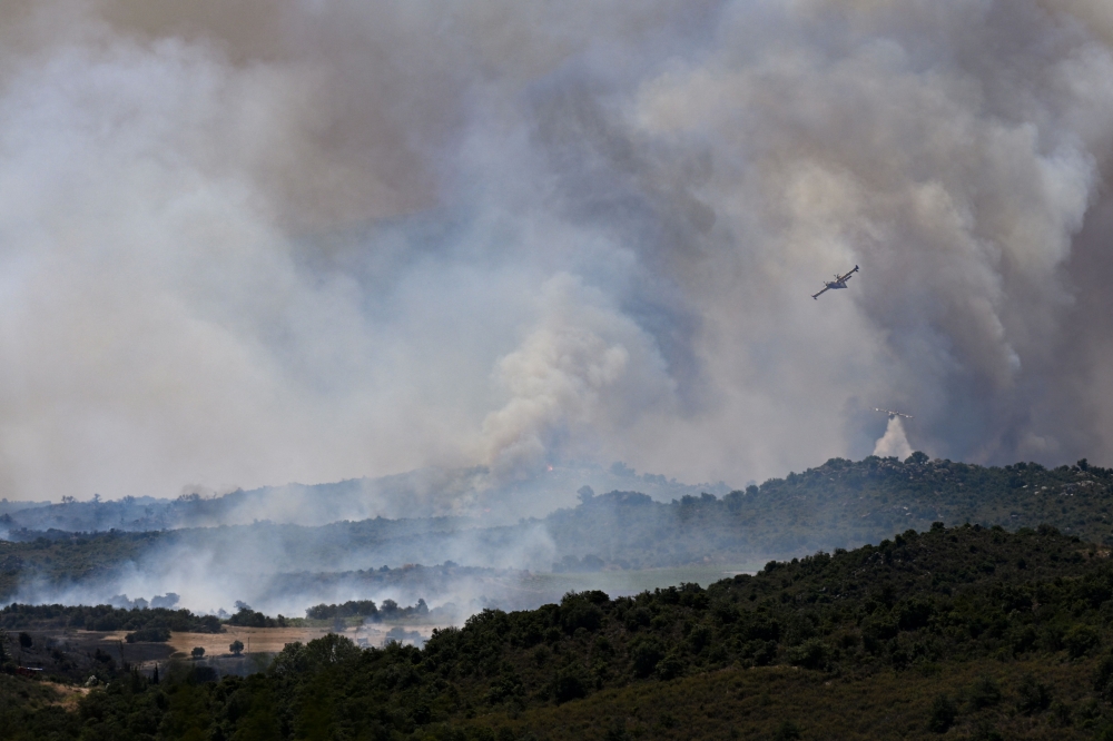 Canadair CL-415 aircraft of France's Civil Security services drop water on a wildfire at the Col des Auzines, near Trevillach, southern France, on July 5, 2026.  (Photo by Matthieu RONDEL / AFP)