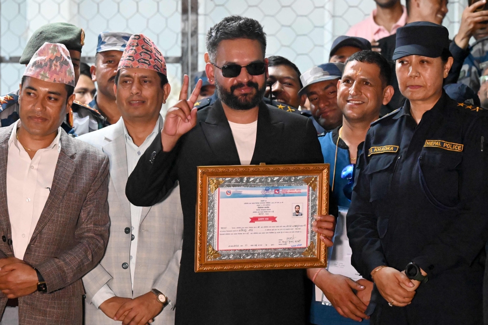 (Files) Rastriya Swatantra Party (RSP) election candidate Balendra Shah (C) shows a victory sign after collecting a certificate following his win in parliamentary elections at the counting centre in Damak in Nepal's Jhapa district on March 7, 2026. Photo by Prakash Mathema / AFP