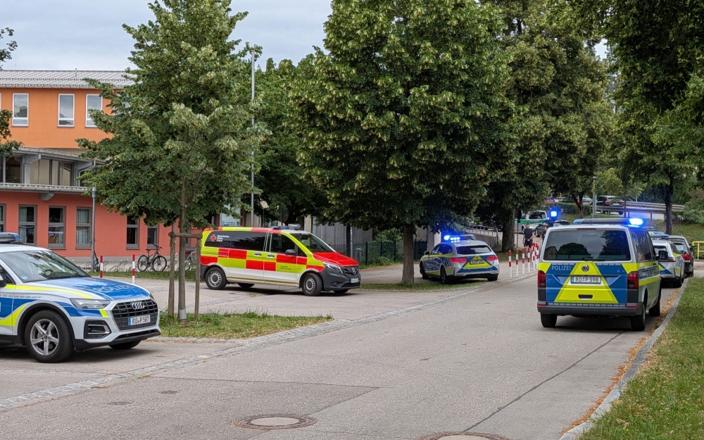 Cars by Police and rescue personnel are parked near the secondary school Schongau, in the southern German state of Bavaria, where several people have been wounded and a suspect arrested in an attack on July 8, 2026.  (Photo by Christoph PETERS / DPA / AFP)
