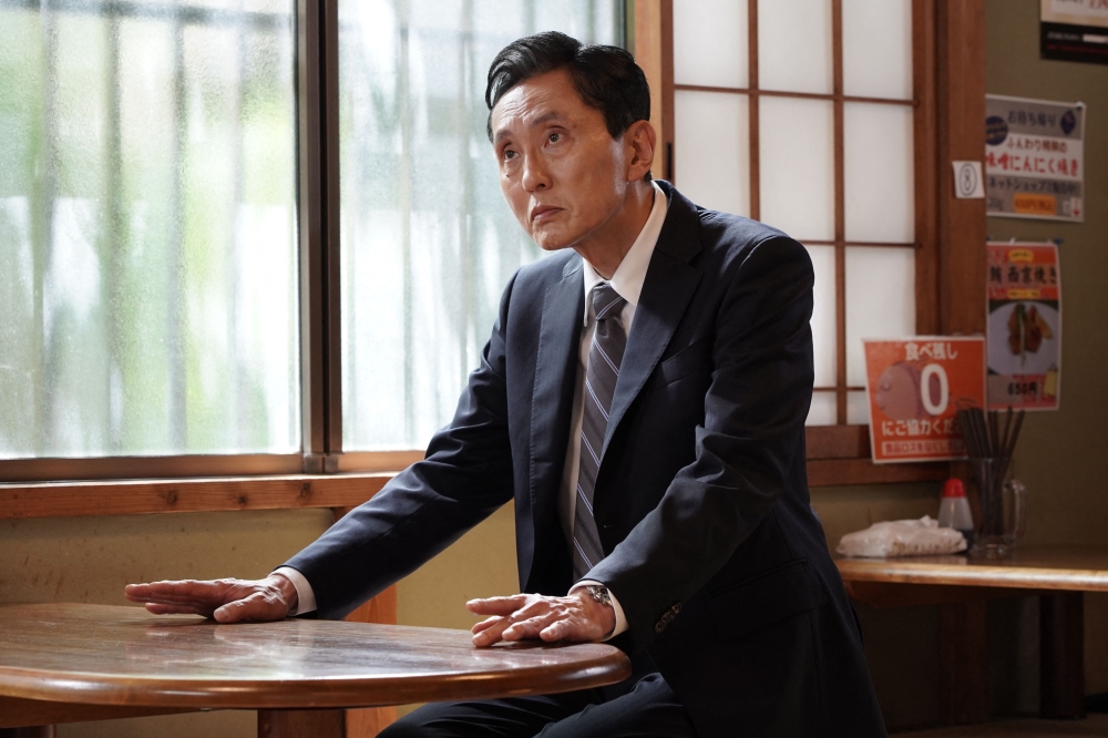 Japanese actor Yutaka Matsushige performs a dining scene during the filming of an episode of the TV drama series 