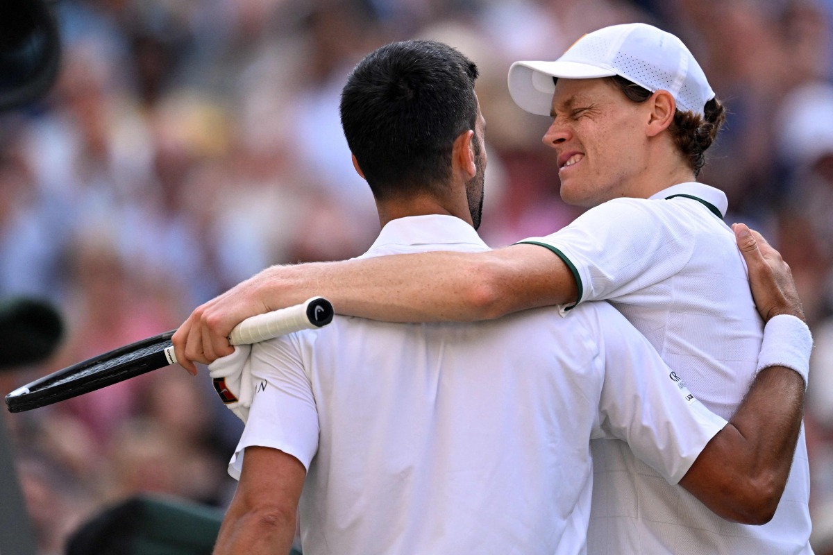 Italy's Jannik Sinner winks at Serbia's Novak Djokovic after beating him during their men's singles semi-final tennis match on the twelfth day of the 2026 Wimbledon Championships at The All England Lawn Tennis and Croquet Club in Wimbledon, southwest London, on July 10, 2026. (Photo by Kirill KUDRYAVTSEV / AFP) 