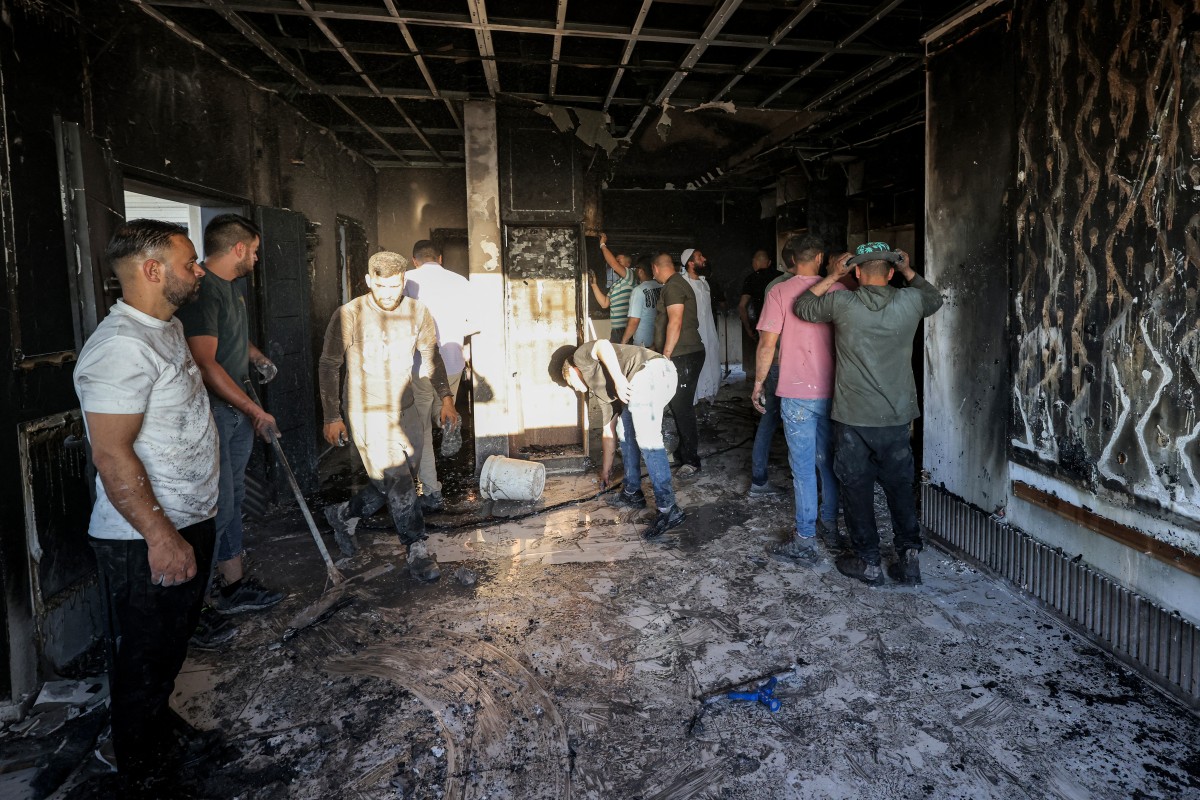 Palestinians watch as a fire blazes near the village of Tell, west of Nablus in the occupied West Bank on July 18, 2026, after a reported arson attack by Israeli settlers on the village, according to eyewitnesses. Photo by JAAFAR ASHTIYEH / AFP