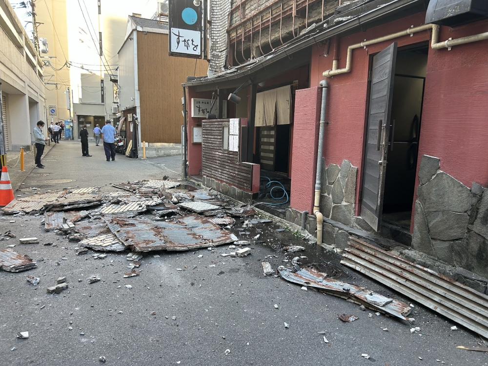 The exterior wall of a shop is seen collapsed in an earthquake, in Kumamoto City on July 28, 2026. (Photo by JIJI Press / AFP) / Japan OUT