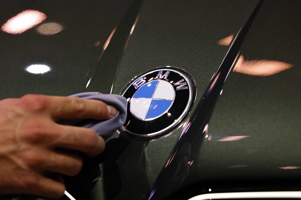 (Files) A staff member cleans the car logo of a BMW at the International Motor Show IAA on September 8, 2025, in Munich, southern Germany. (Photo by Alexandra Beier / AFP)
 
