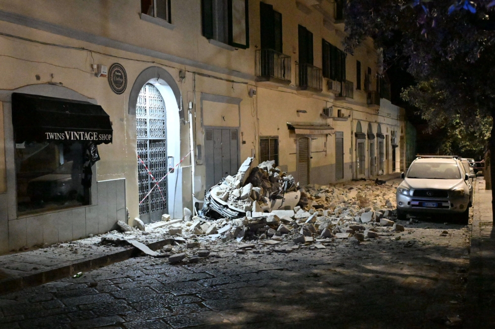 This photograph shows a car crushed by rubble after a magnitude 4.7 earthquake struck the Campi Flegrei area in Pozzuoli, near Naples on July 31, 2026. (Photo by Felice DE MARTINO / ANSA / AFP) /