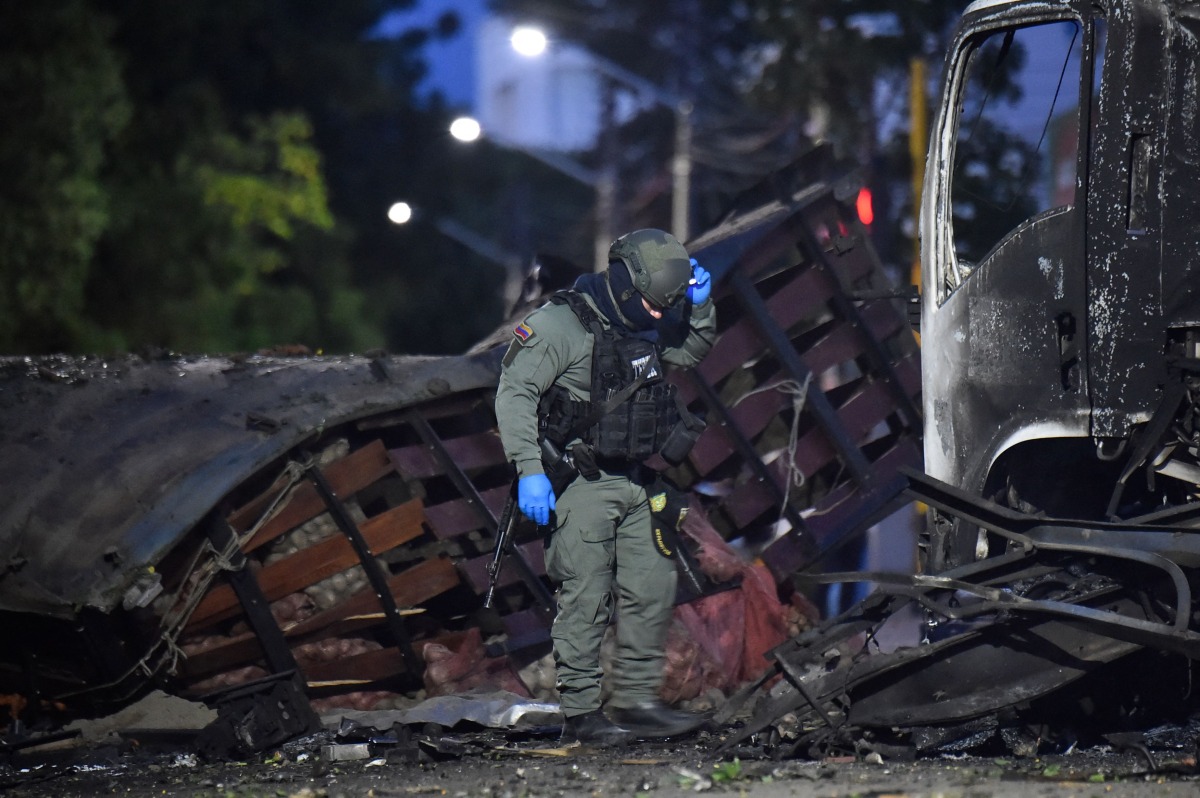 A police officer inspects the wreckage of a truck after a car bomb detonated near a police station in Cucuta, Colombia, on August 1, 2026. (Photo by Schneyder Mendoza / AFP)