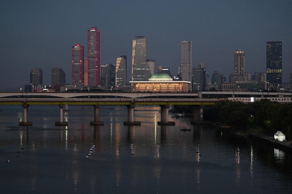 Buildings are seen behind a bridge over the Han River in Seoul on August 1, 2026. (Photo by Greg Baker / AFP)