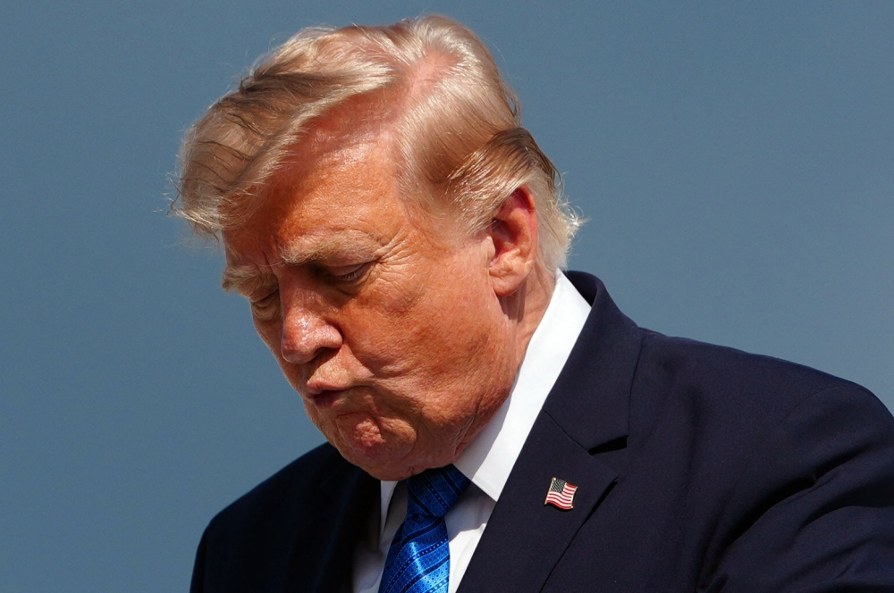 US President Donald Trump gestures while stepping off Air Force One upon arrival at Morristown Municipal Airport in Morristown, New Jersey, on July 31, 2026. (Photo by Aaron Schwartz / AFP)
 