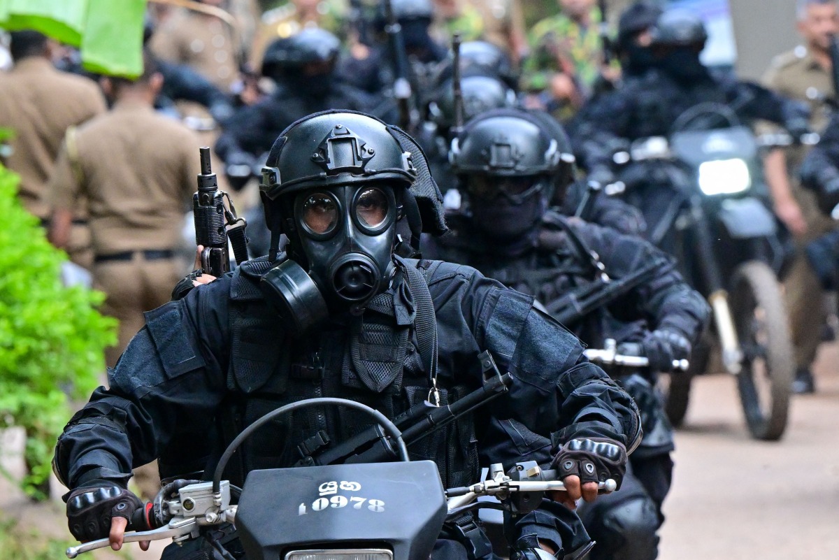 Military personnel wearing anti-riot gear patrol on bikes outside the Mahara Prison complex on the outskirts of Colombo on August 2, 2026. Photo by Ishara S. KODIKARA / AFP