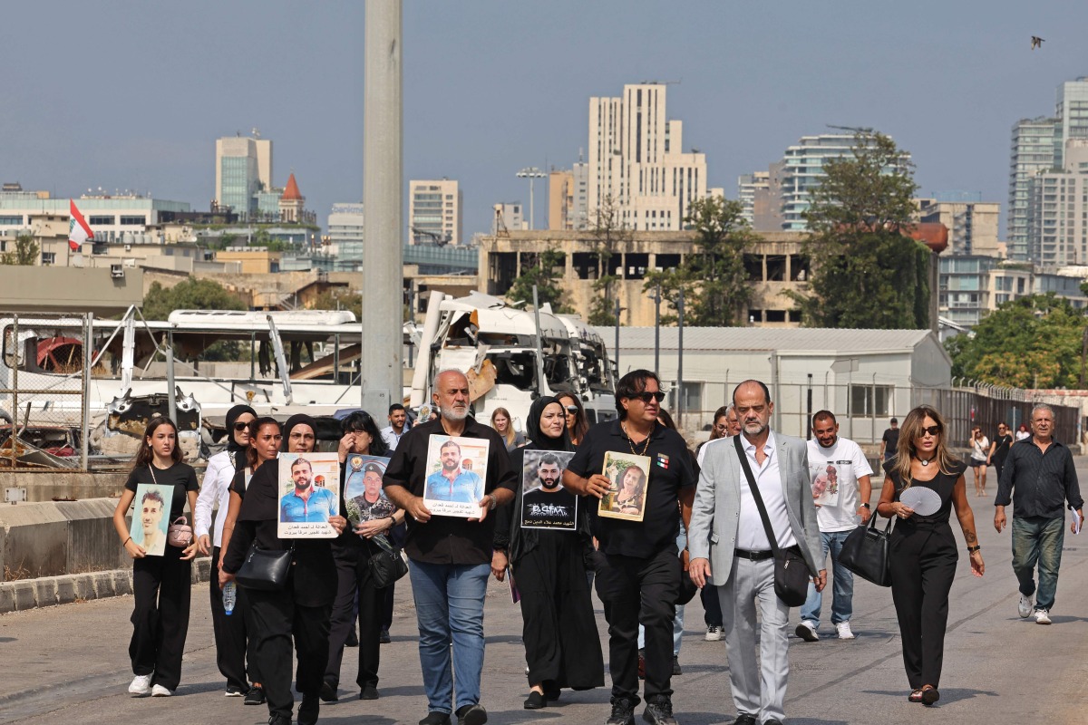 Family members march while carrying the portraits of the victims of 2020 Beirut port blast near the blast's ground zero on the sixth anniversary of the explosion, in Beirut on August 4, 2026. Photo by Anwar AMRO / AFP