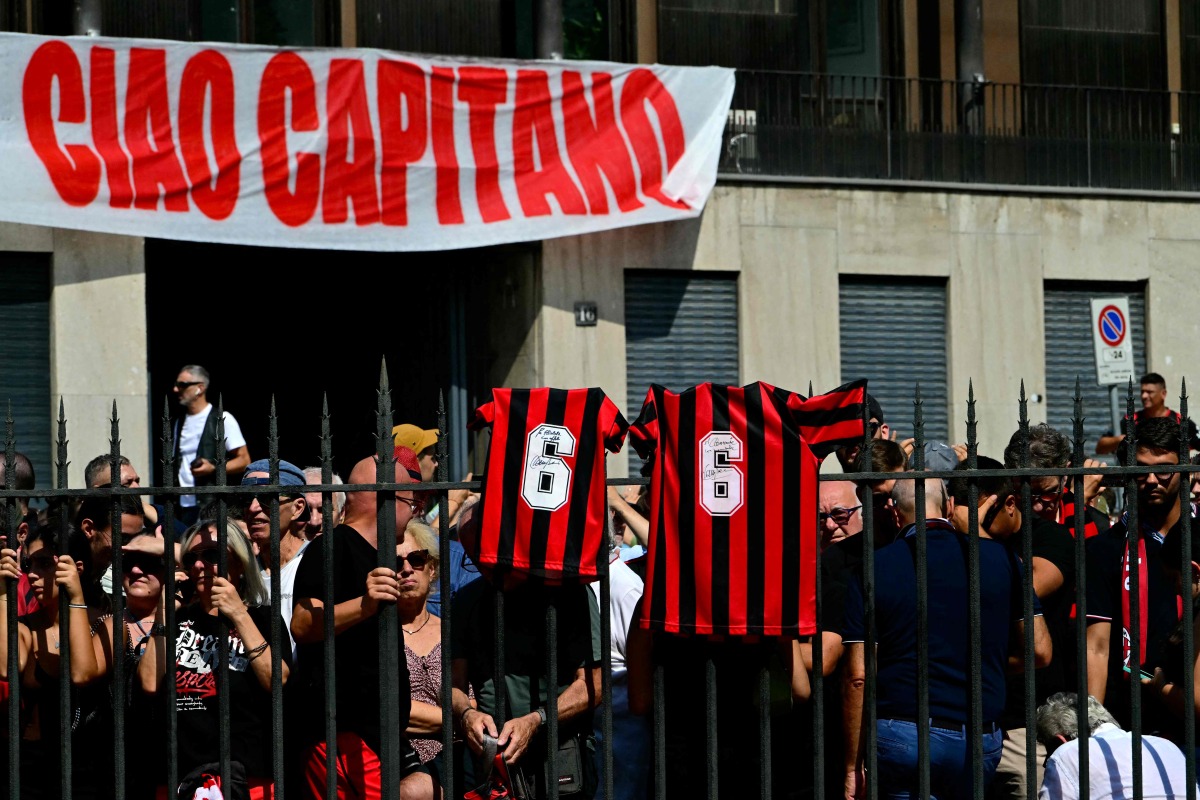 AC Milan supporters gather for the funeral of late AC Milan football player Franco Baresi outside the Sant但mbrogio Basilica in Milan on August 4, 2026. (Photo by Stefano RELLANDINI / AFP)