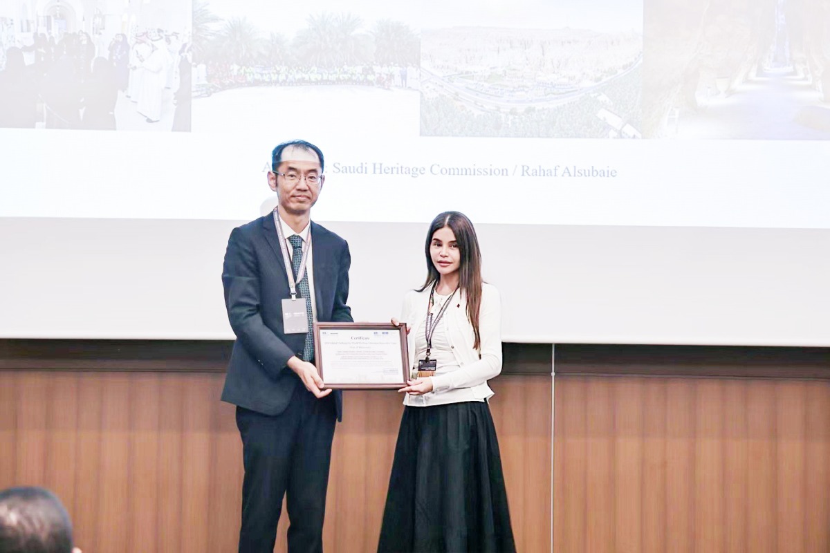A Qatar Museums representative receives the award from an official during the ceremony in Busan, Republic of Korea.