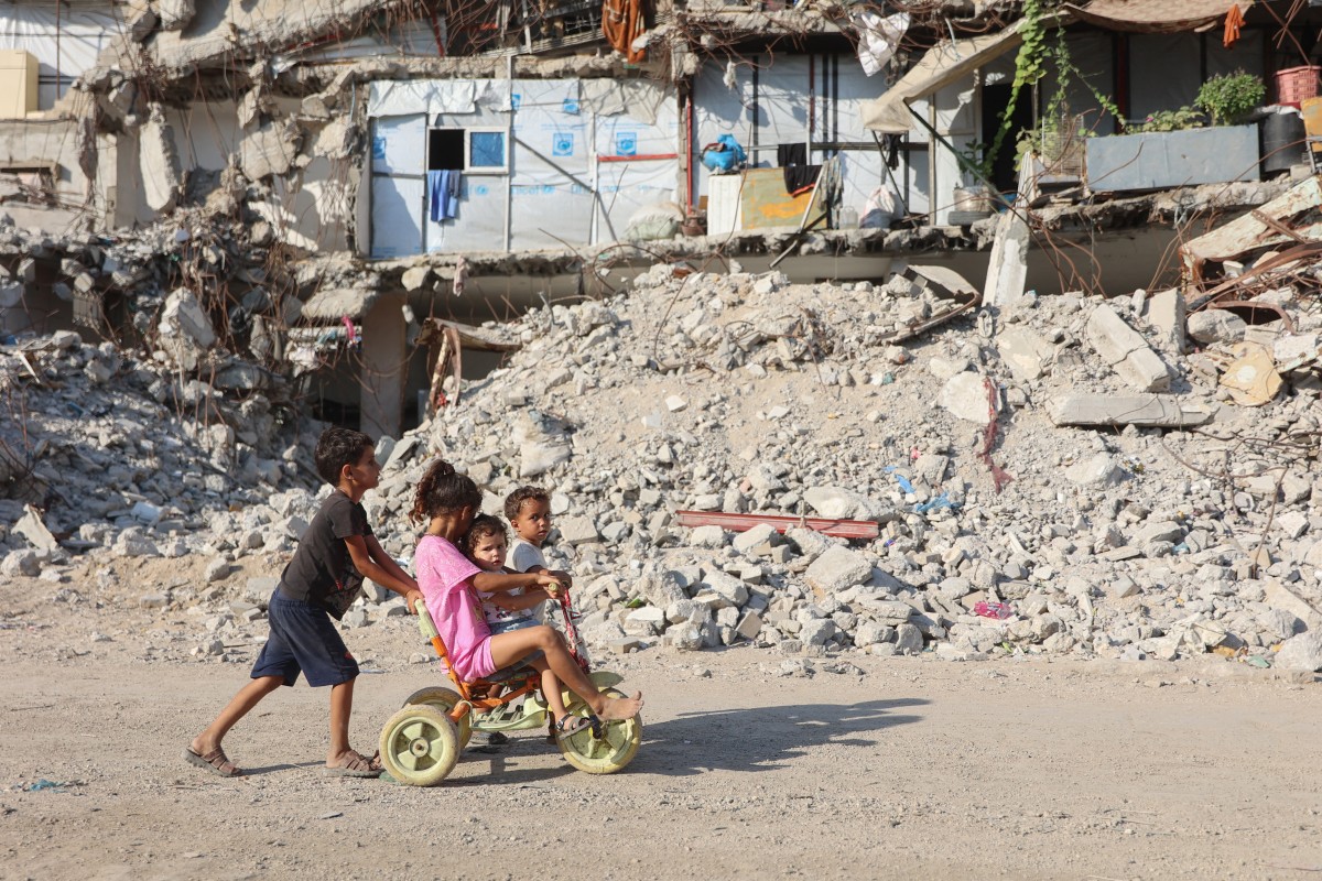 Palestinian children play near the rubble of destroyed buildings in Gaza City on August 2, 2026. Photo by OMAR AL-QATTAA / AFP
