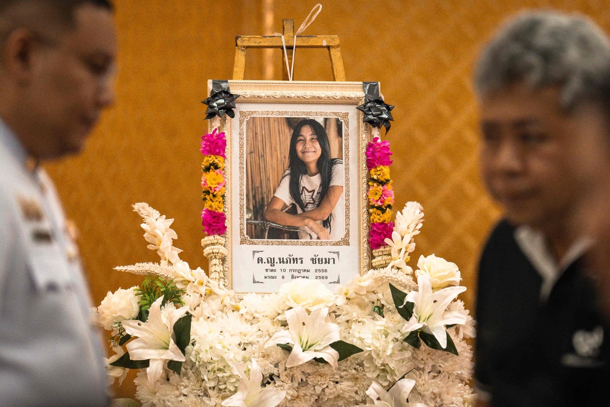 A portrait of 12-year-old school shooting victim Naphat Chaima is displayed in front of the coffin during her funeral at the Wat Lat Pla Duk Buddhist temple in Nonthaburi province, north of Thailand's capital Bangkok, on August 9, 2026. Photo by Chanakarn LAOSARAKHAM / AFP