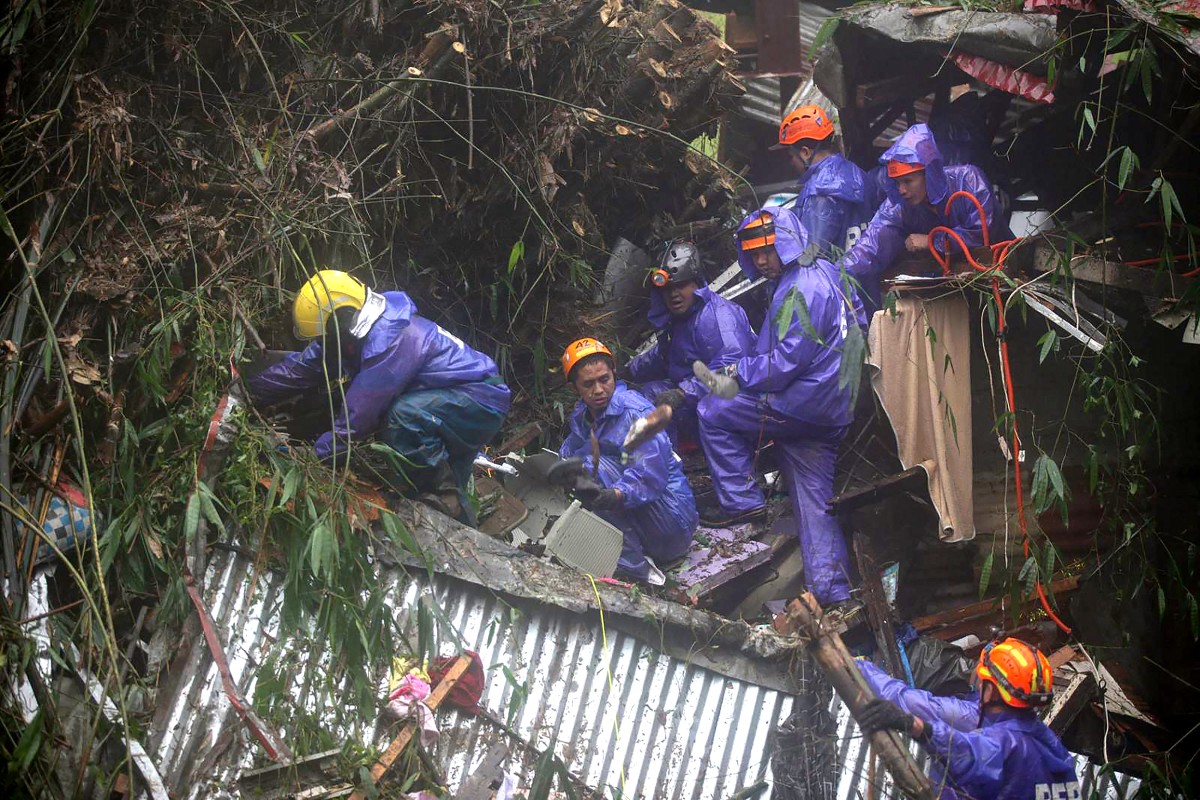 Rescuers sift through rubble as they search for survivors after a rain-drenched mountainside collapsed on several houses in Baguio City, north of Manila, on August 10, 2026. Photo by JJ LANDINGIN / AFP