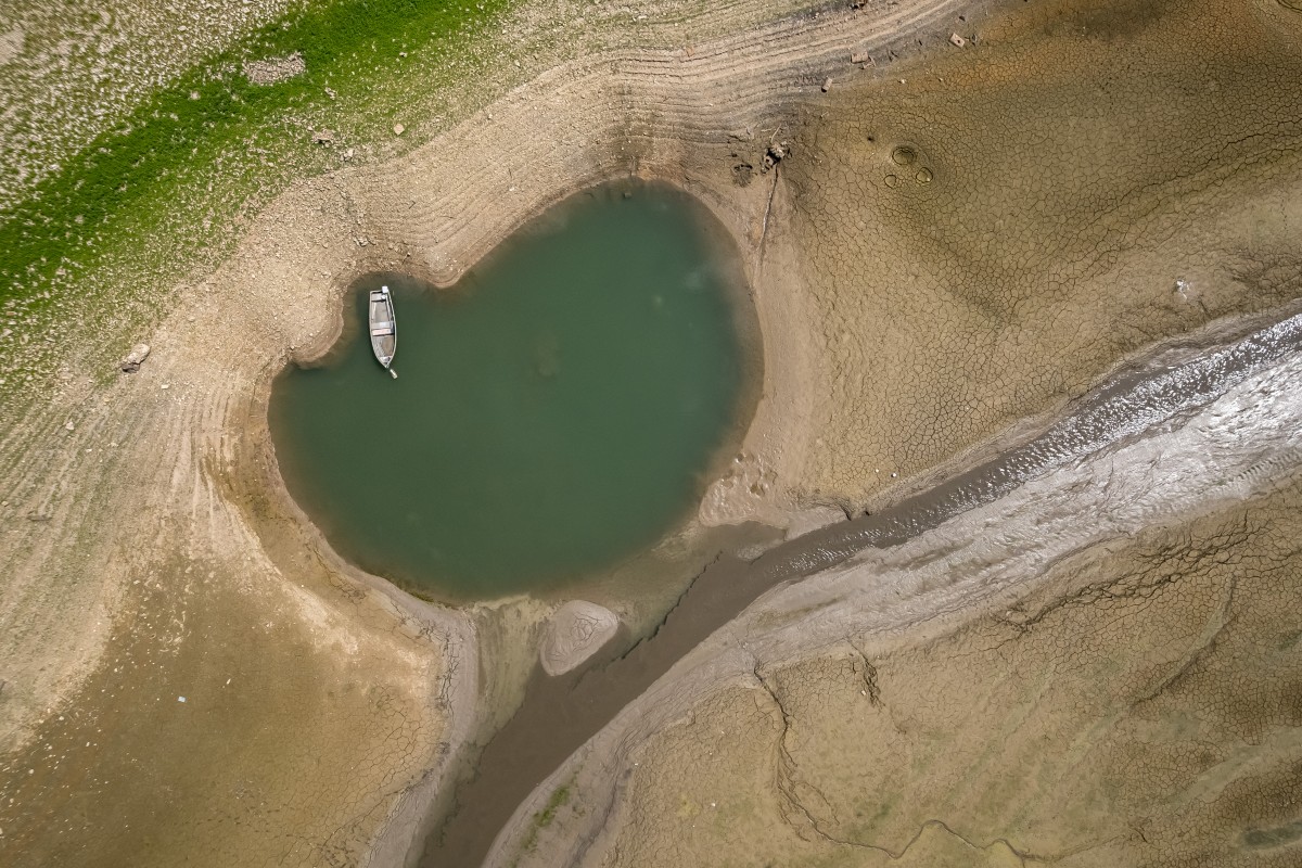 This aerial photograph shows the parched bed of Brenets Lake (Lac des Brenets), part of the Doubs River, a natural border between eastern France and western Switzerland, as central Europe is hit by a new heatwave, in Les Brenets on August 11, 2026. Photo by FABRICE COFFRINI / AFP