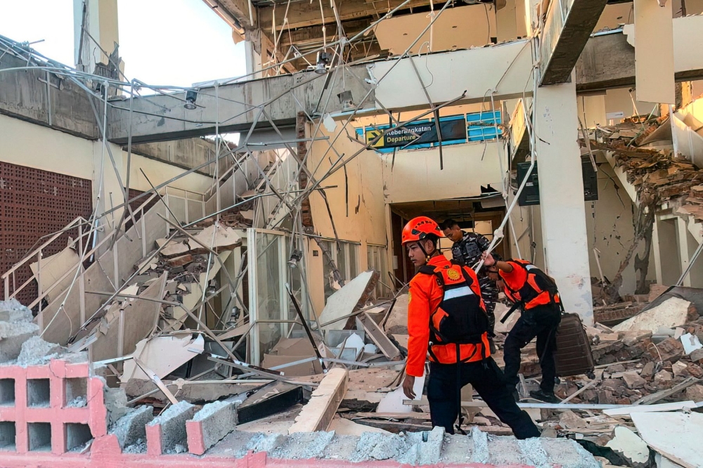 This handout picture taken and released on August 15, 2026 by Indonesia's National Search and Rescue Agency (BASARNAS) shows rescuers working amid the rubble of a damaged building after an earthquake in Maumere, East Nusa Tenggara. (Photo by Handout / INDONESIA'S NATIONAL SEARCH AND RESCUE AGENCY (BASARNAS) / AFP)
