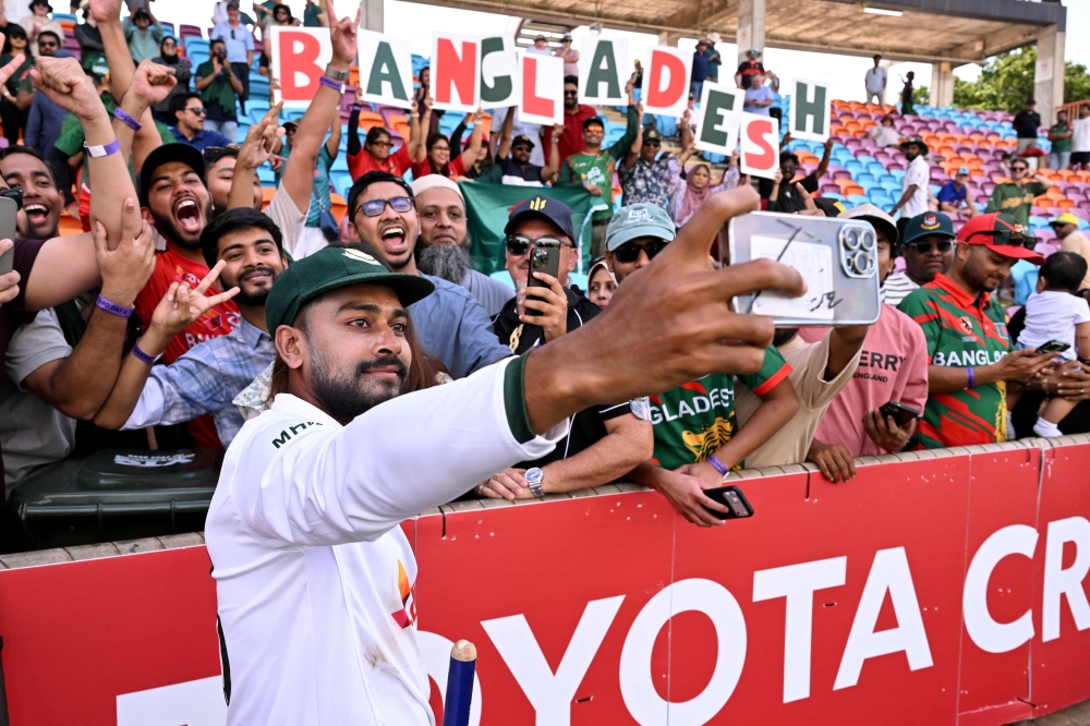 Bangladesh player Mehidy Hasan Miraz poses with fans after victory against Australia on the fourth day of the first cricket Test match between Australia and Bangladesh at Marrara Stadium in Darwin on August 16, 2026. (Photo by William WEST / AFP)