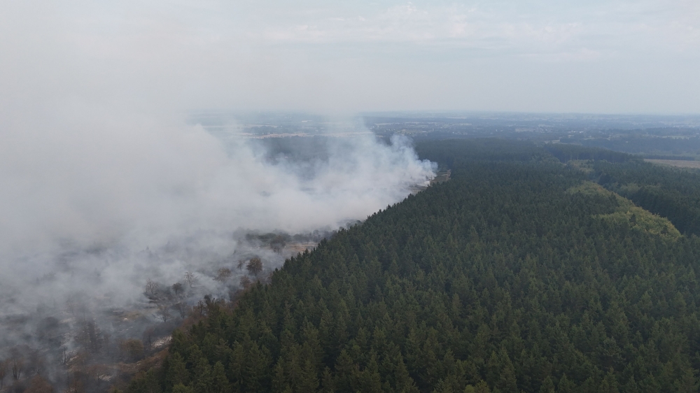 This aerial photograph shows a wildfire burning in the Hautes Fagnes (High Fens) nature reserve in Waimes on August 15, 2026. (Photo by Dimitri KORCZAK / AFP)