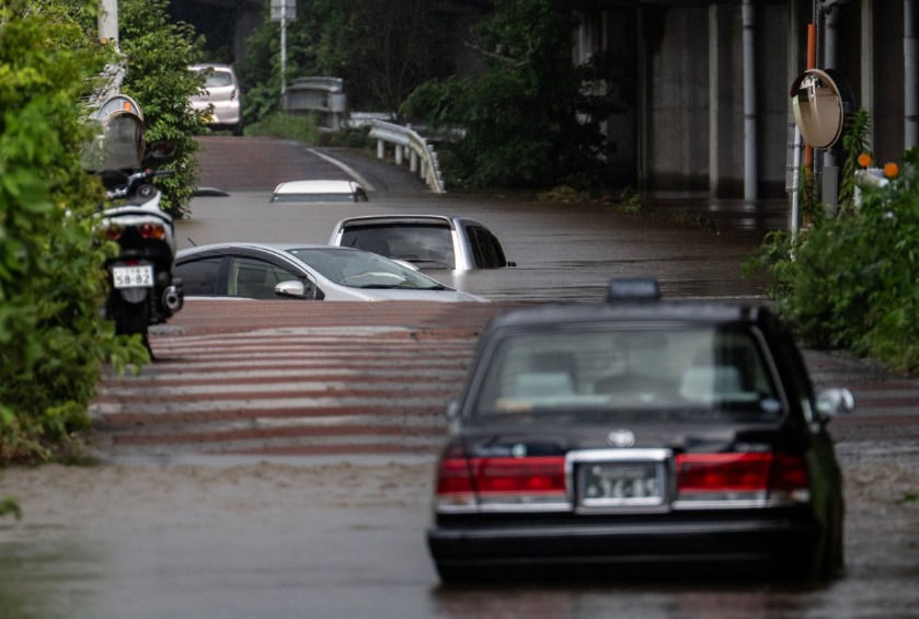 Abandoned cars partially submerged on a flooded road in Chiba prefecture. AFP file photo.