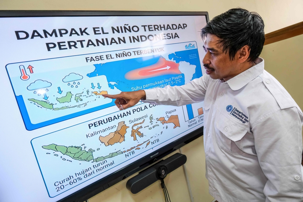 This picture taken on August 6, 2026 shows I Putu Santikayasa, hydroclimatology lecturer at IPB University, explaining the impact of El Nino in Indonesia, in Bogor, West Java. Indonesia believes cloud seeding can help it tackle a wildfire season that experts say is on track to be among the worst in years, driven by a strong El Nino. (Photo by BAY ISMOYO / AFP)