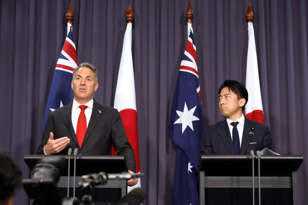 Japan's Defence Minister Shinjiro Koizumi (R) stands with Australian Deputy Prime Minister and Defence Minister Richard Marles (L) during a press conference at Parliament House in Canberra on August 18, 2026. (Photo by HILARY WARDAUGH / AFP)