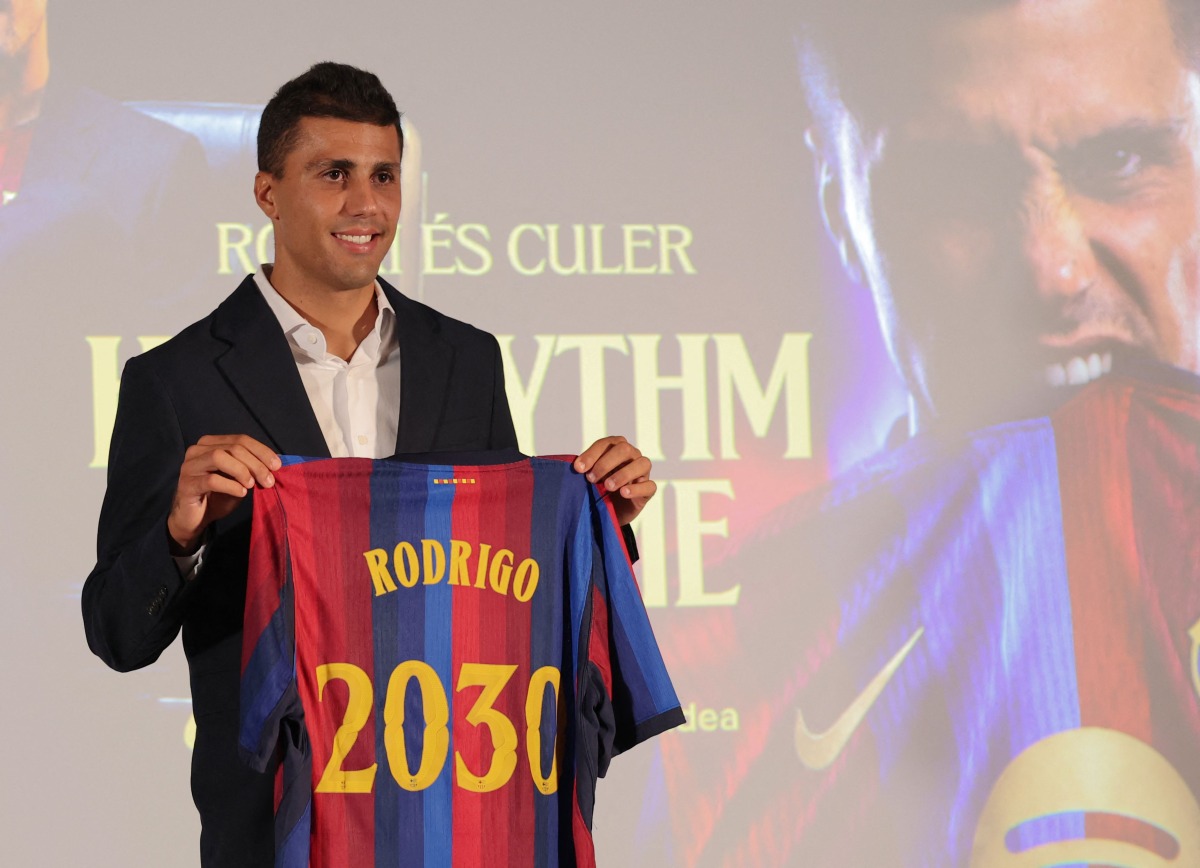 Spanish international footballer Rodri poses with a jersey bearing his name during his official presentation as FC Barcelona's new player on August 18, 2026 in Barcelona. (Photo by Lluis GENE / AFP)