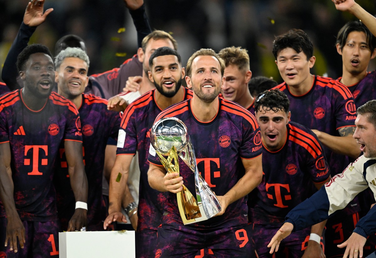 Bayern Munich's English forward #09 Harry Kane (C) holds the trophy as he celebrates with his teammates winning the Franz Beckenbauer Supercup football match between Borussia Dortmund and FC Bayern Munich on August 22, 2026 in Dortmund, western Germany. (Photo by INA FASSBENDER / AFP)
