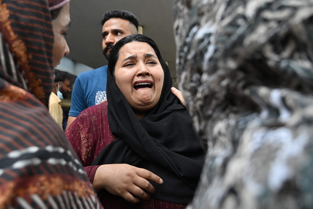 A mother reacts after the death of her child following a fire incident outside the Mother and Child Health (MCH) ward at the Pakistan Institute of Medical Sciences (PIMS) Hospital in Islamabad on August 26, 2026. (Photo by Aamir QURESHI / AFP)