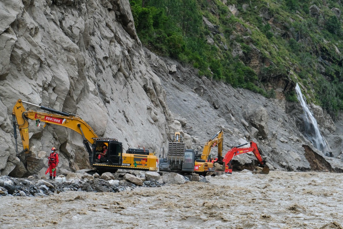 Workers use excavators to clear debris and rebuild the mudslide-damaged road which leads to Gyirong Port in Gyirong County, in China's western Tibet region on August 30, 2026. Photo by CNS / AFP