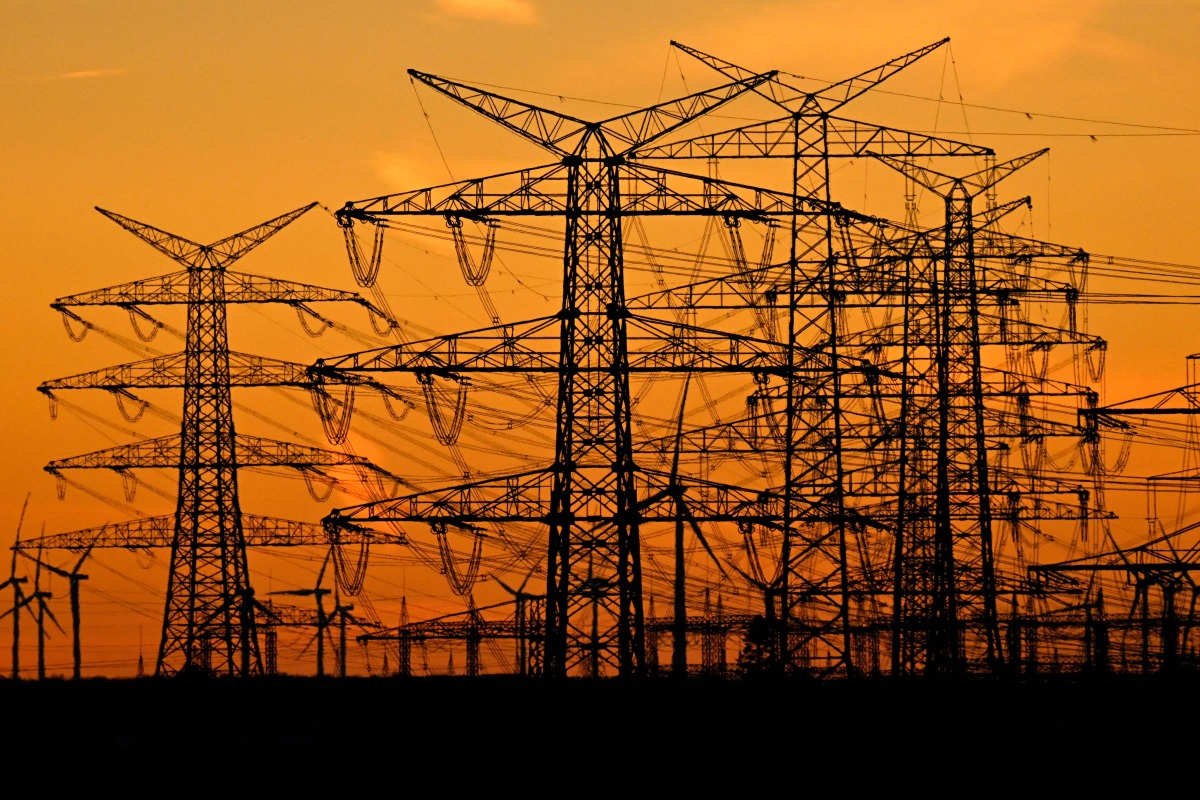 This picture taken on November 12, 2025 shows power poles near the lignite-fired power station operated by German energy giant RWE near Niederaussem, part of Bergheim, western Germany. Photo by Ina FASSBENDER / AFP
